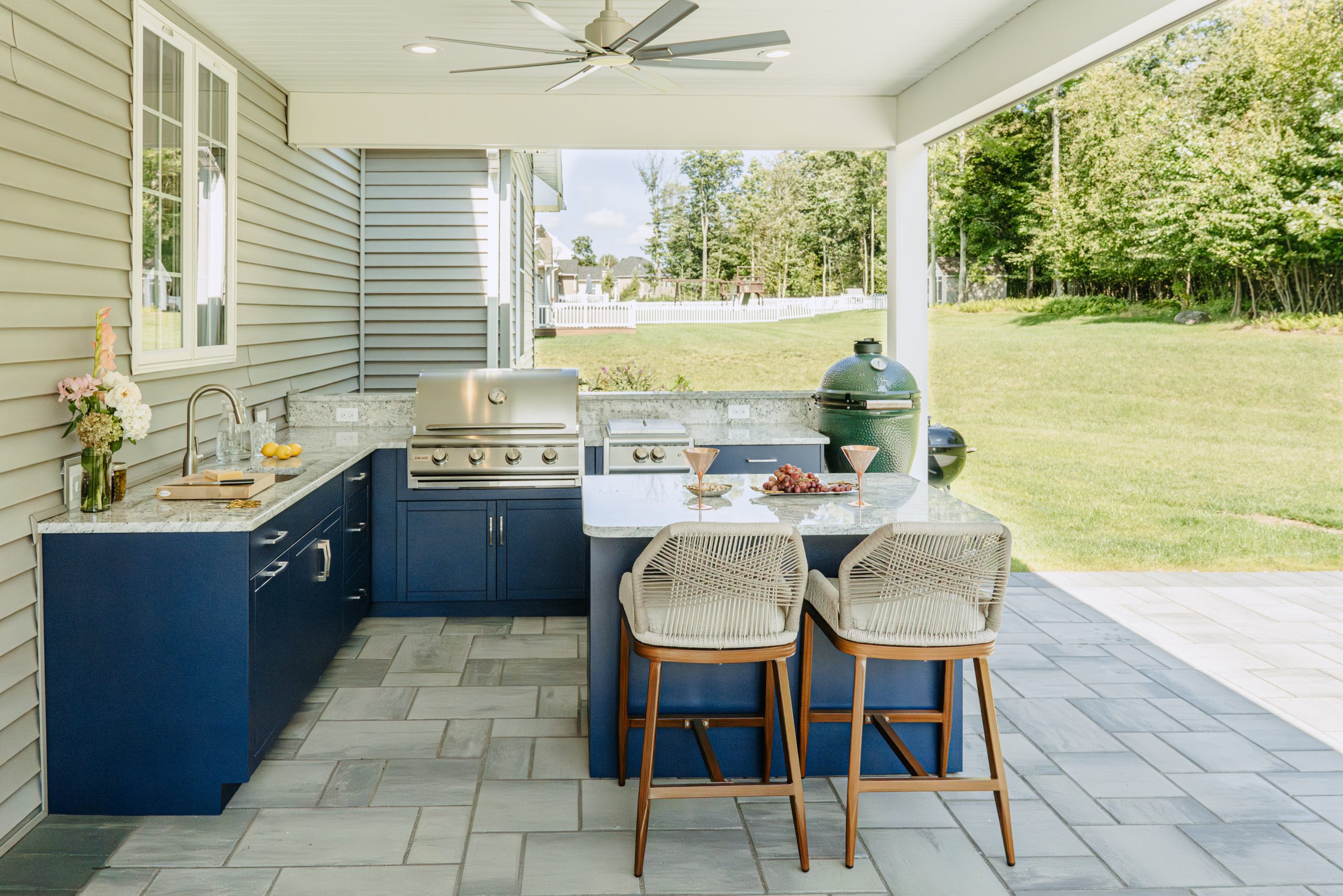 Open Air Cabinetry August Blue outdoor kitchen with granite counters, grill, and covered seating area
