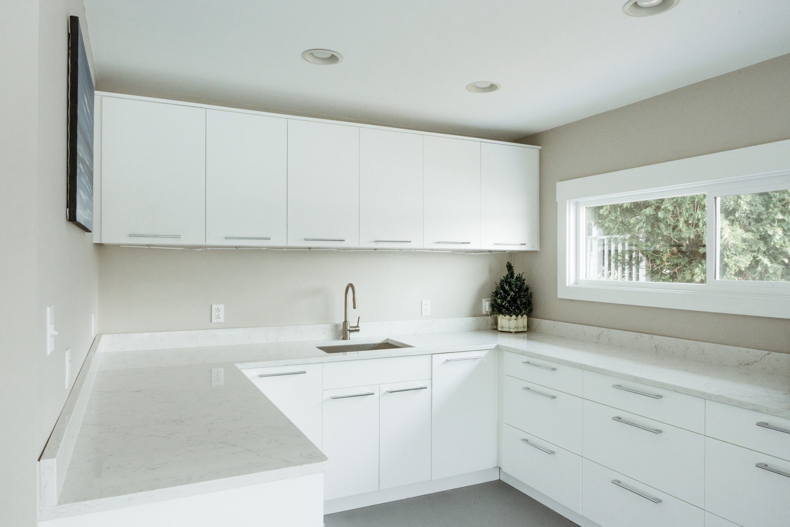 Open Air Outdoor Cabinetry Modern kitchen with white cabinetry, marble countertop, and sink